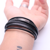 Brede heren armband van gevlochten zwart leer en zwartkleurig magnetische roestvrij stalen sluiting. Fashion, mode, heren, mannen